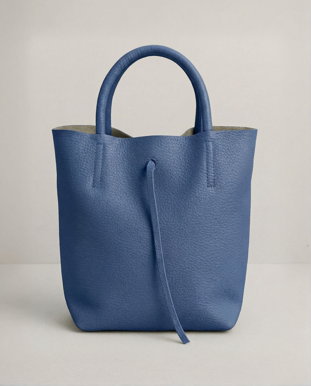 Mini tote in pebble leather Royal blue with structured silhouette and top handles, compact and bold design. 