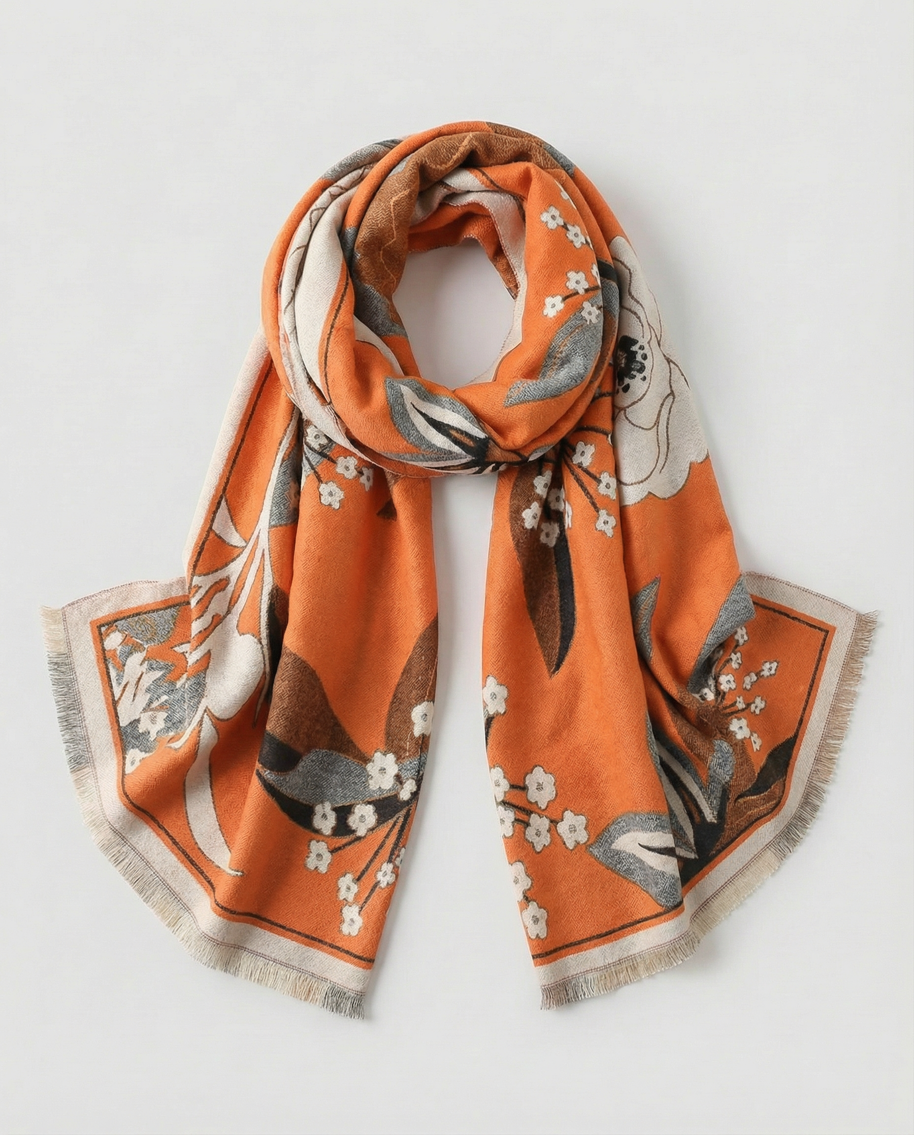 Orange floral scarf with an illustrated botanical pattern in cream, brown, and gray tones, finished with soft fringed edges, displayed folded on a white background.
