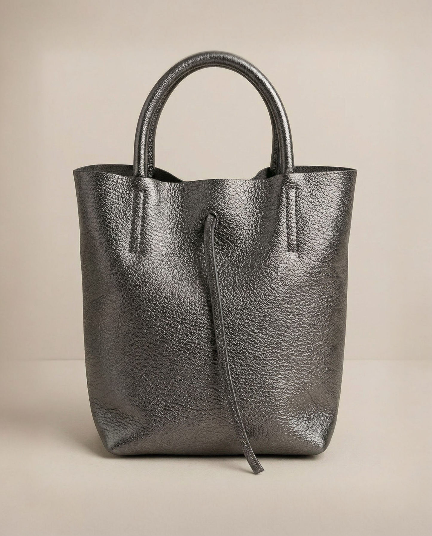 Mini tote in metallic pewter leather with structured silhouette and top handles, sleek and compact design.