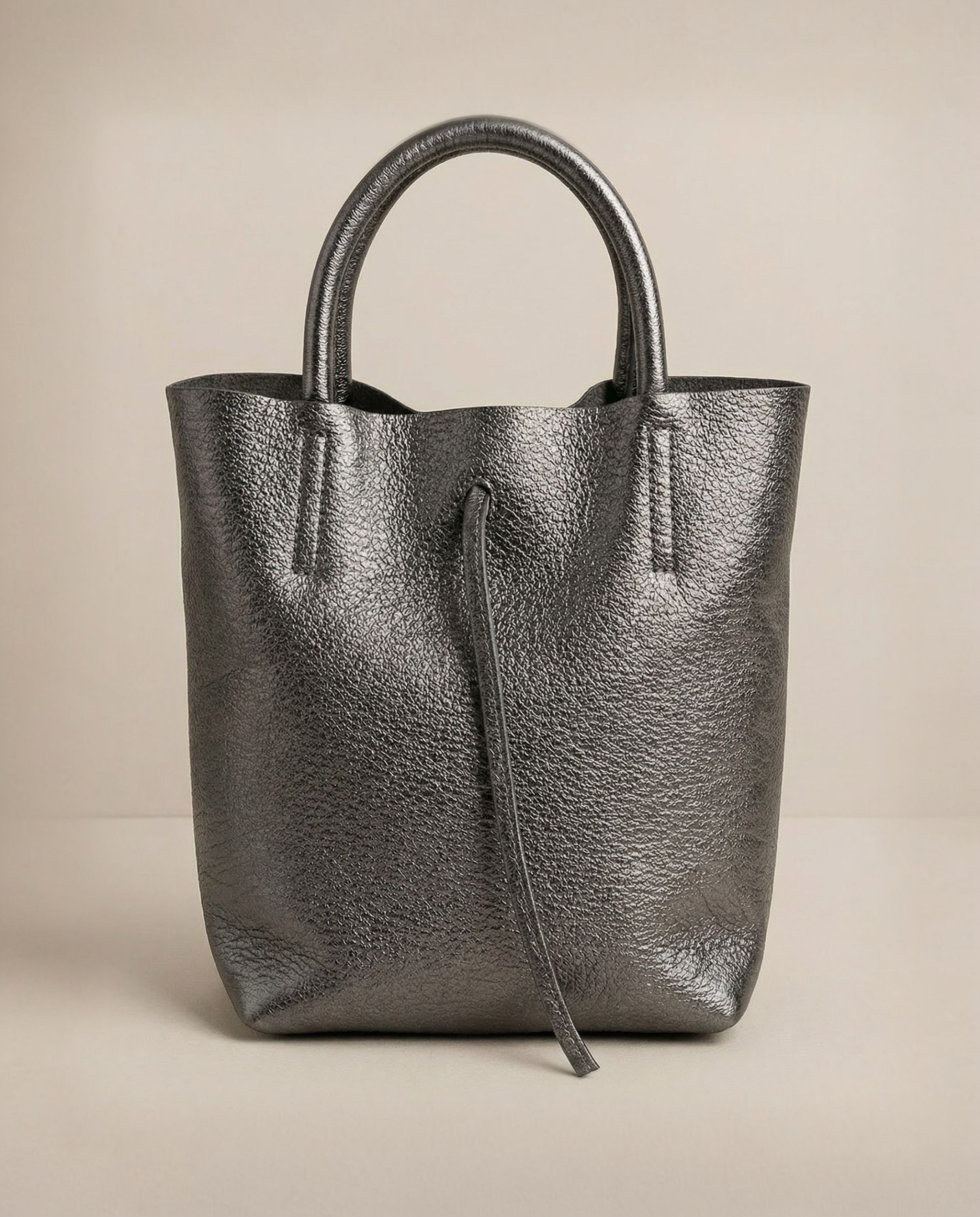 Mini tote in metallic pewter leather with structured silhouette and top handles, sleek and compact design.
