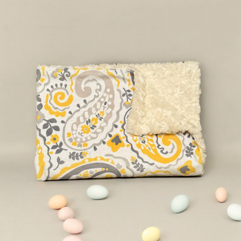 Soft baby blanket with paisley yellow design perfect for cozy newborn snuggles.