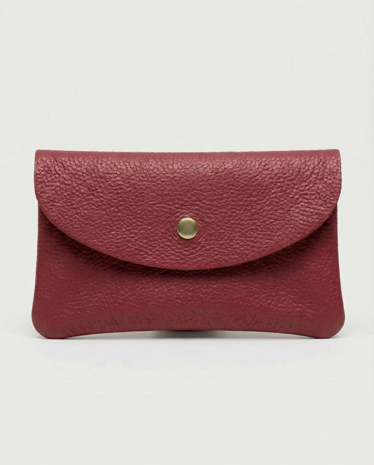 Pebble leather wallet in cranberry with a gold button on a white background