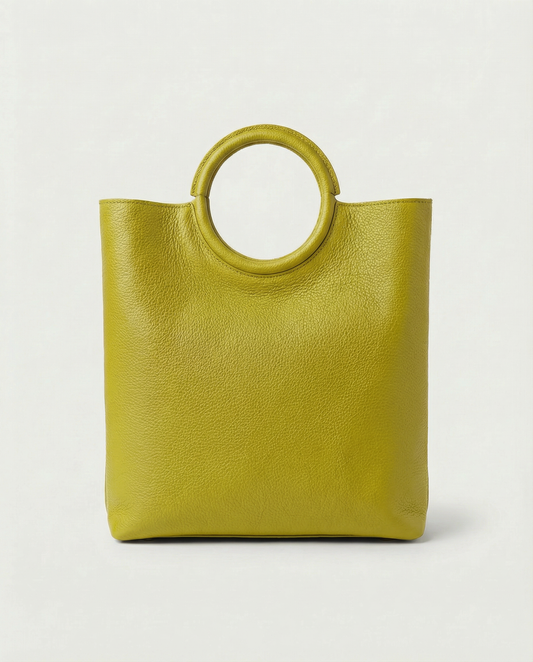 Ring Bag in pebble leather chartreuse with circular ring handle and structured silhouette.