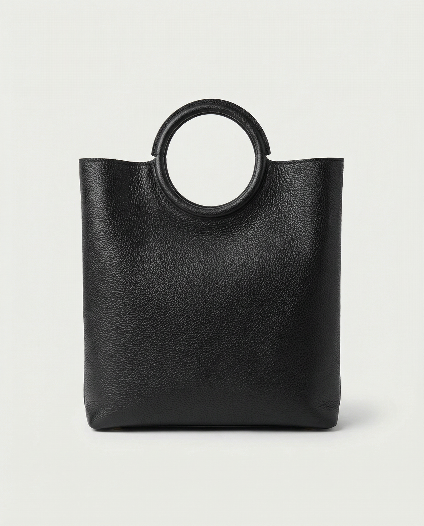Ring Bag in pebble leather black with circular ring handle and structured silhouette.