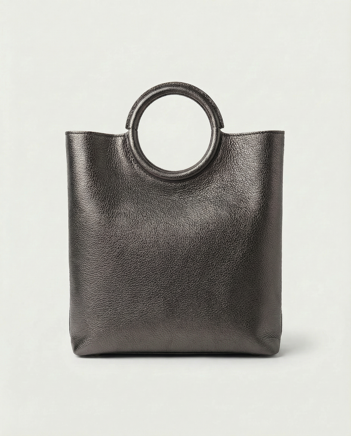 Metallic pewter leather ring bag with circular top handle and structured silhouette, sleek and modern design.