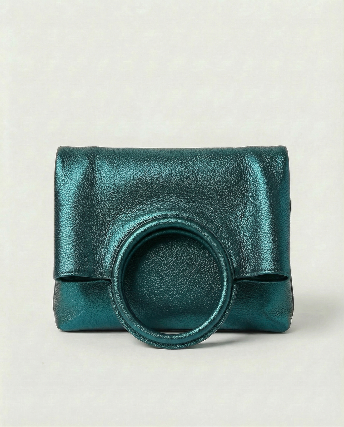 Metallic teal leather ring bag with circular top handle and structured silhouette, sleek and modern design.