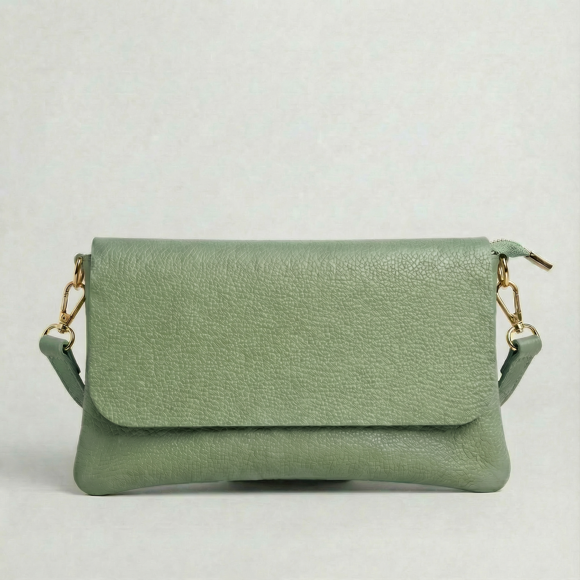 Spruce pebble leather crossbody bag with a matching color adjustable strap, displayed on a light gray background.