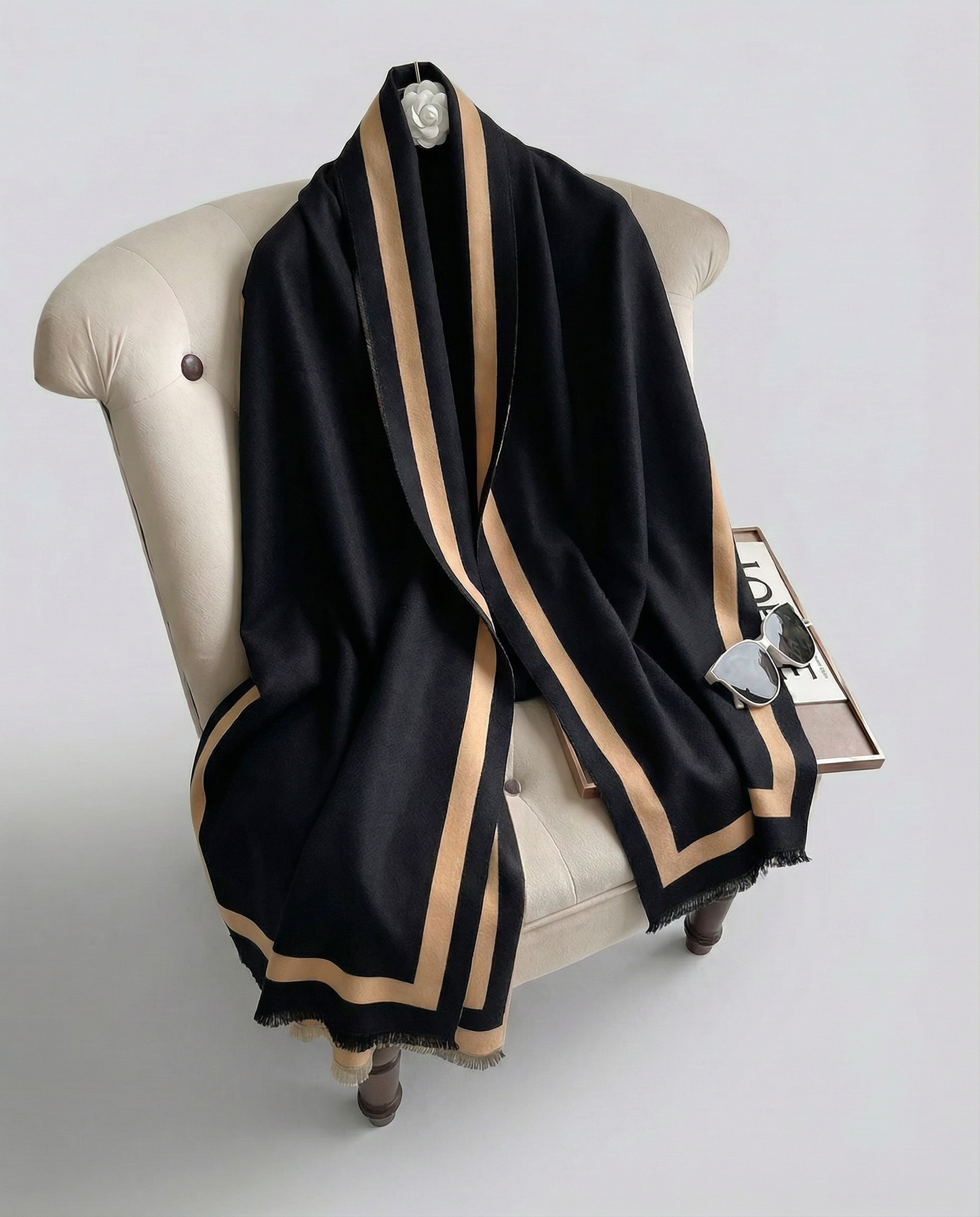 Black and beige wrap draped over a mannequin on a white background