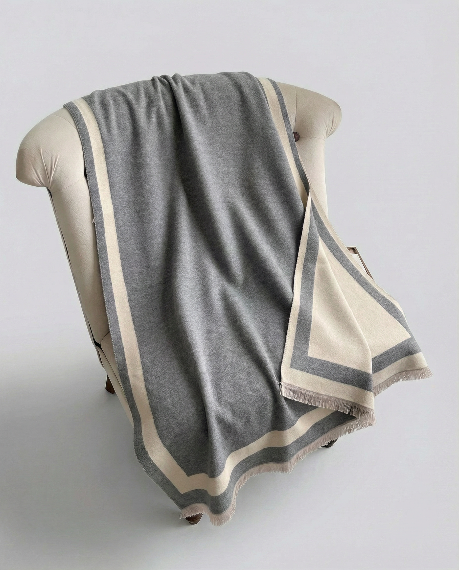 Gray and beige striped wrap draped over a chair on a light gray background