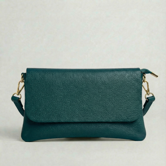 Teal pebble leather crossbody bag with a matching color adjustable strap, displayed on a light gray background.