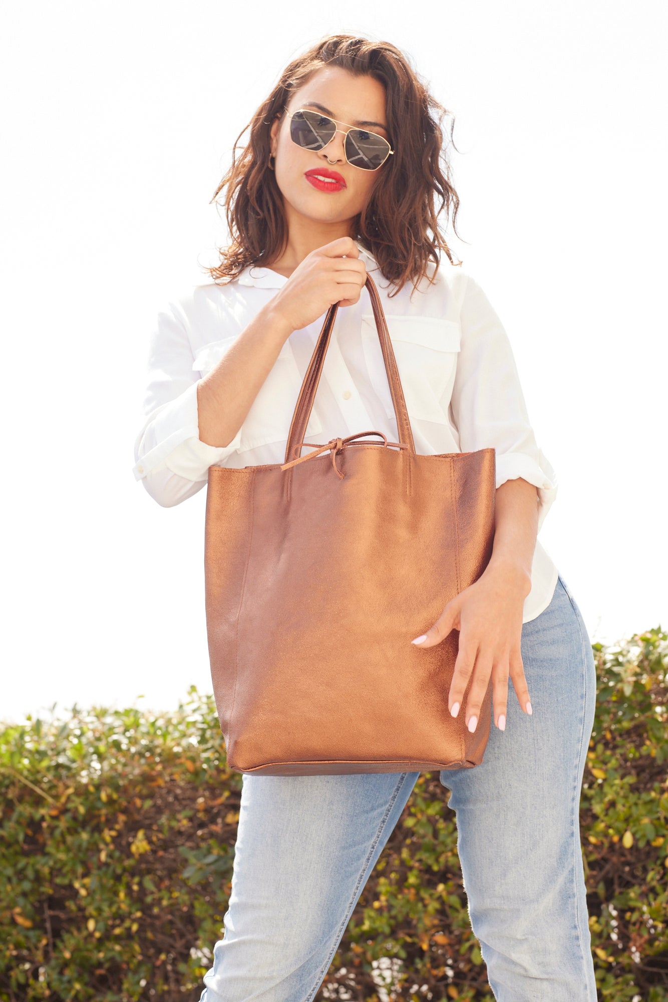 Women with poses with copper tote bag.