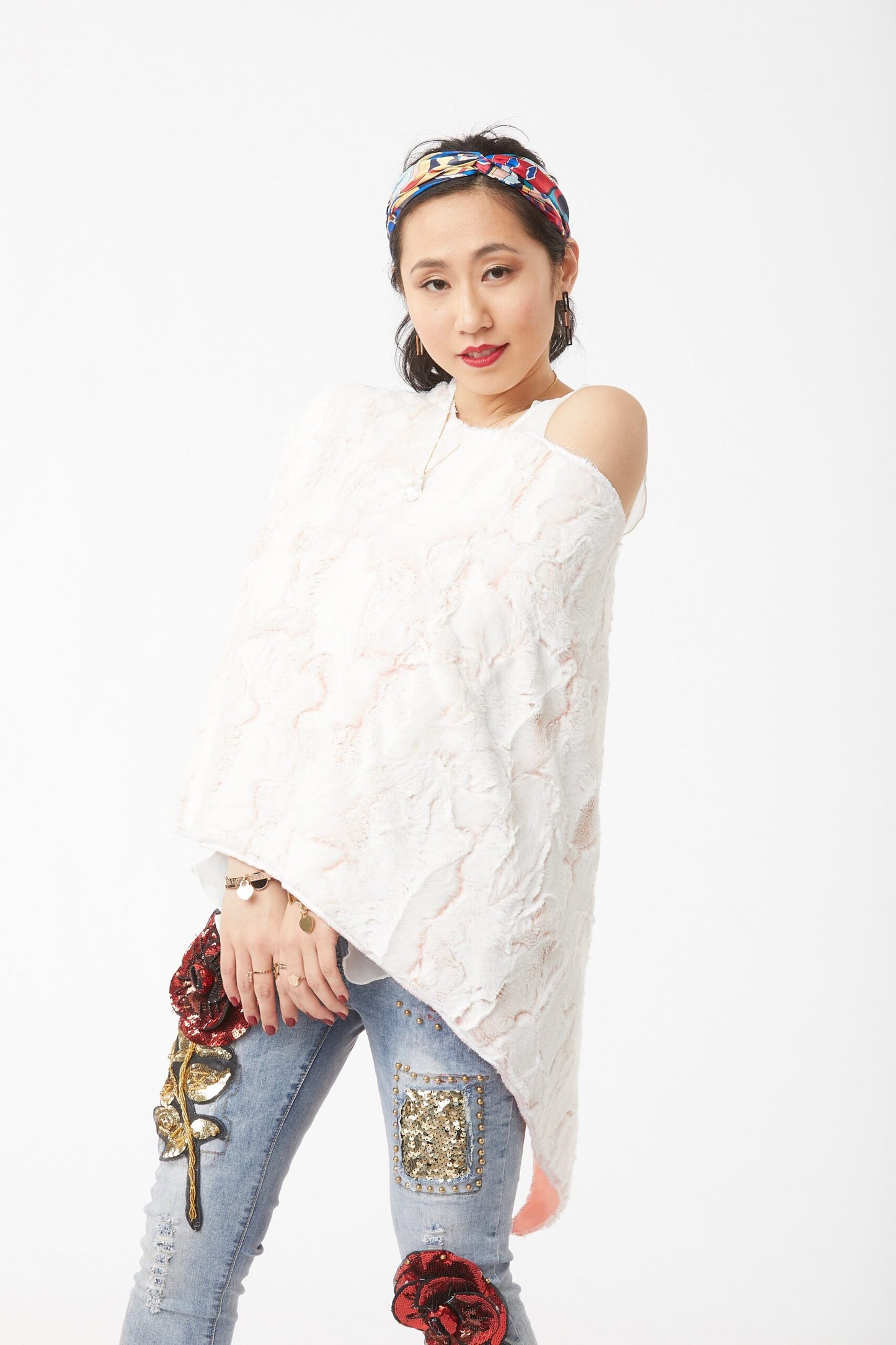 Woman poses wearing a Cream and Blush Lux Rabbit Duo Tone Poncho
