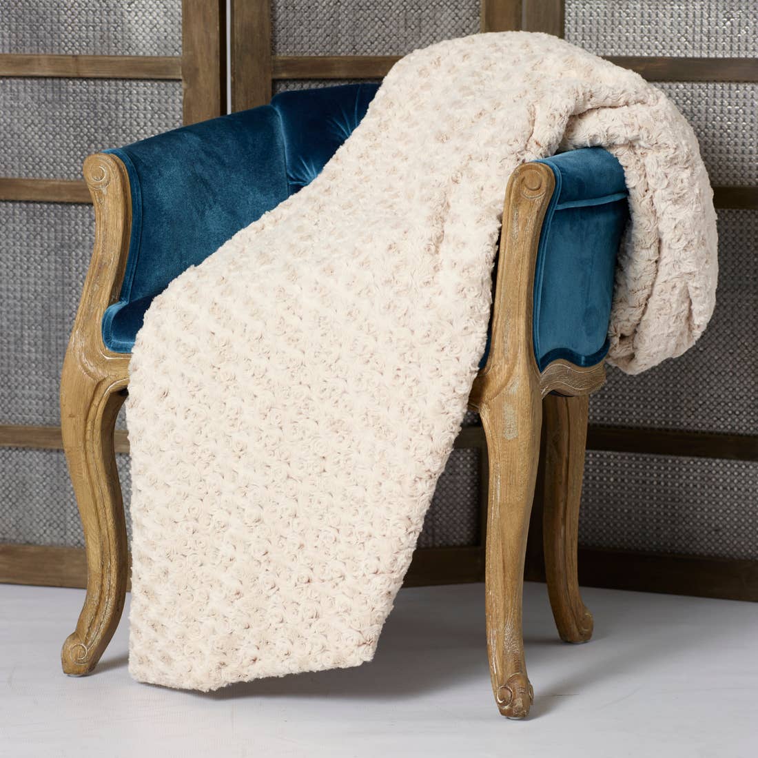 Rosebud Duotone Throw in Cream & Sahara on blue chair